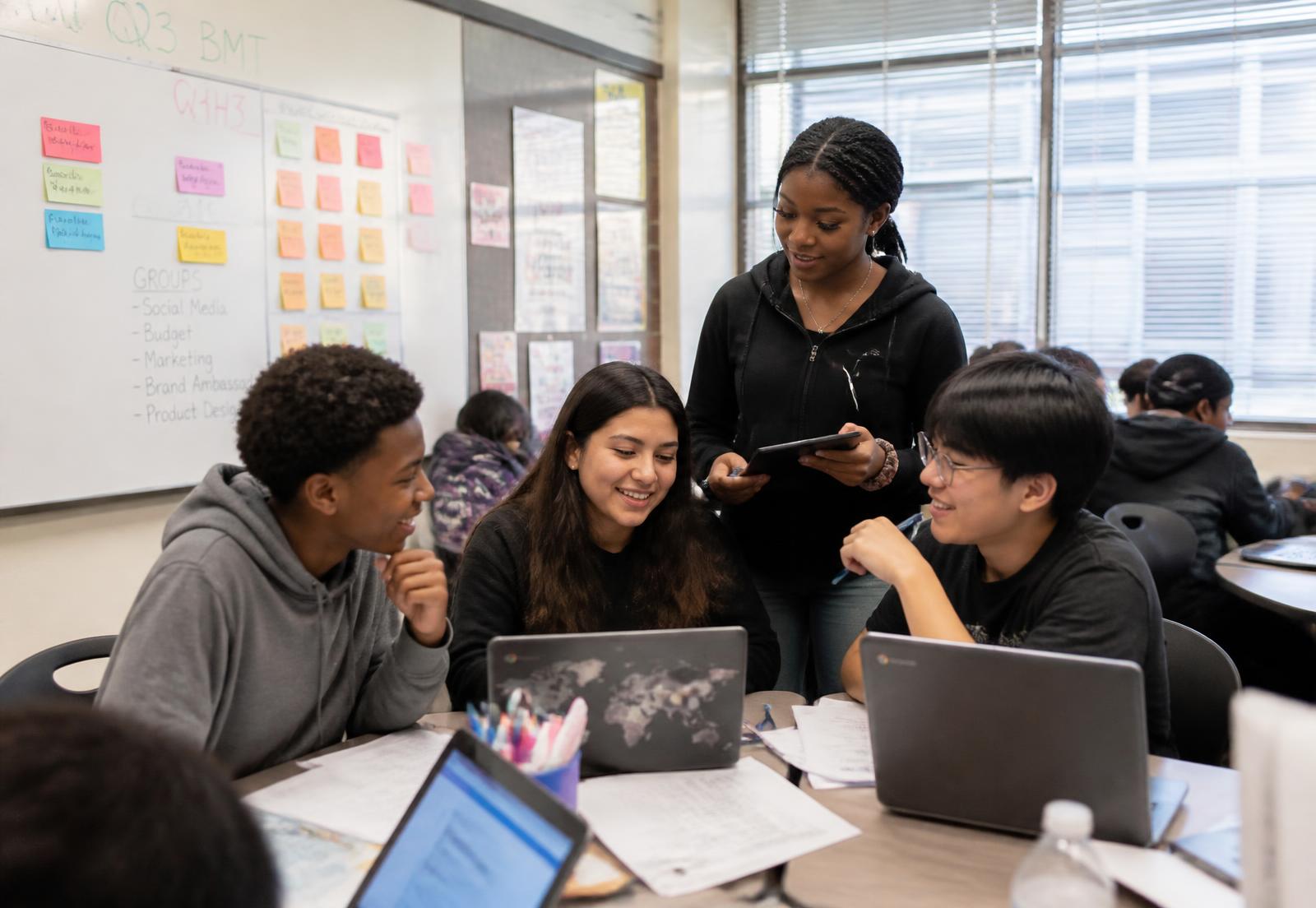 Diverse high school students collaborating on a Y.E.W.P. business project in a Philadelphia classroom